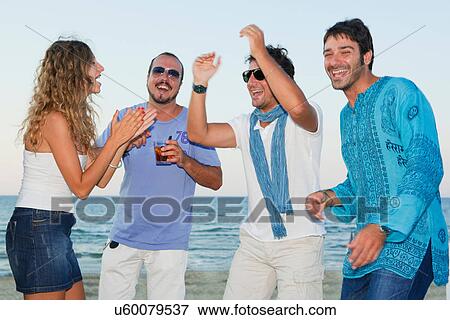 Friends laughing together on beach View Large Photo Image Stock Photo - Friends laughing together on beach. Fotosearch