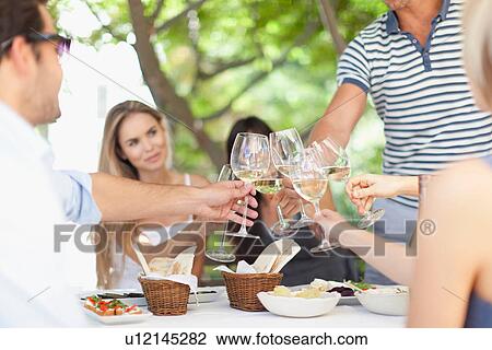 Friends toasting each other outdoors View Large Photo Image Stock Image - Friends toasting each other outdoors. Fotosearch