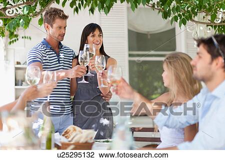 Friends toasting each other outdoors View Large Photo Image Stock Image - Friends toasting each other outdoors. Fotosearch