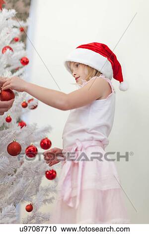 Girl decorating Christmas tree View Large Photo Image Stock Image - Girl decorating Christmas tree. Fotosearch