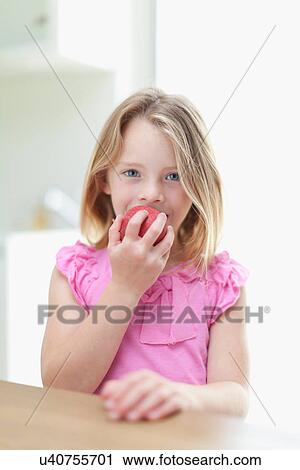Girl eating apple in kitchen View Large Photo Image Stock Image - Girl eating apple in kitchen. Fotosearch
