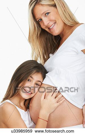 Girl hugging pregnant mother's belly View Large Photo Image Stock Photo - Girl hugging pregnant mother's belly. Fotosearch