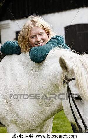 Picture - Girl hugging white horse outdoors. Fotosearch