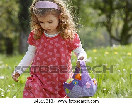 Girl hunting for Easter eggs View Large Photo Image Stock Photo - Girl hunting for Easter eggs. Fotosearch