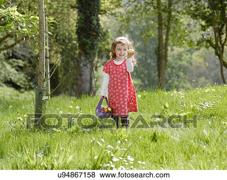 Girl hunting for Easter eggs View Large Photo Image Stock Photo - Girl hunting for Easter eggs. Fotosearch