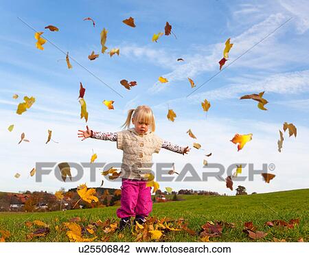 Girl playing in fall leaves View Large Photo Image Stock Image - Girl playing in fall leaves. Fotosearch