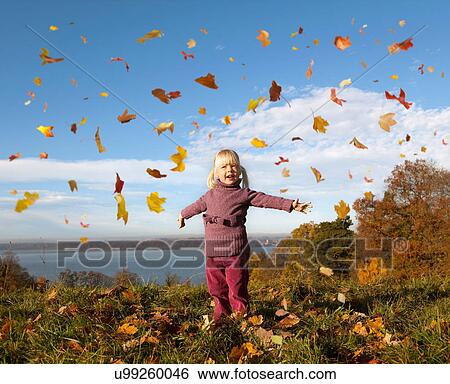 Girl playing in fall leaves View Large Photo Image Stock Photograph - Girl playing in fall leaves. Fotosearch