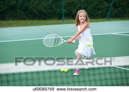 Girl playing tennis on court View Large Photo Image Stock Photo - Girl playing tennis on court. Fotosearch