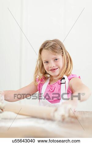 Girl rolling out dough in kitchen View Large Photo Image Stock Image - Girl rolling out dough in kitchen. Fotosearch