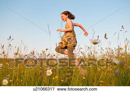 Stock Photo - Girl running in field of flowers. Fotosearch