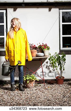Girl watering potted plants outdoors View Large Photo Image Stock Image - Girl watering potted plants outdoors. Fotosearch