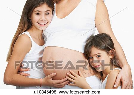 Stock Photo - Girls hugging pregnant mother's belly. Fotosearch