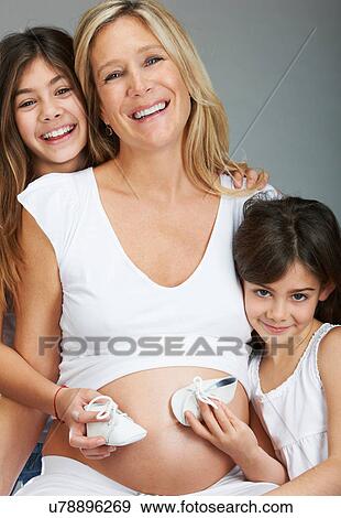 Stock Photo - Girls with booties and pregnant mother. Fotosearch