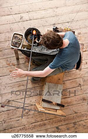Stock Photo - Glassblower shaping hot glass. Fotosearch