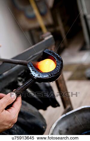 Glassblower shaping hot glass View Large Photo Image Stock Photography - Glassblower shaping hot glass. Fotosearch