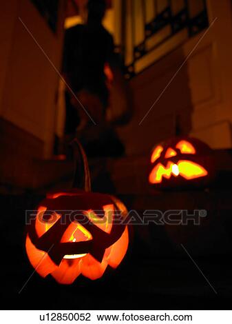 Stock Image - Glowing jack olanterns on front steps. Fotosearch