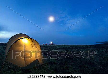Stock Photo - Glowing tent at campsite. Fotosearch