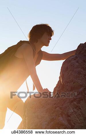 Stock Photo - Hiker climbing rock. Fotosearch