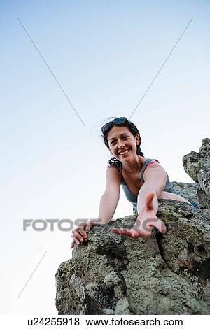 Hiker offering help climbing rock View Large Photo Image Stock Photo - Hiker offering help climbing rock. Fotosearch