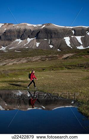 Hiker walking in grassy rural landscape View Large Photo Image Stock Photo - Hiker walking in grassy rural landscape. Fotosearch
