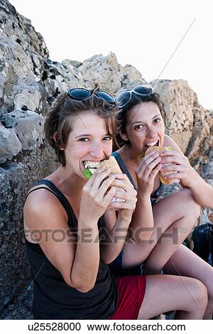 Hikers eating sandwiches on rocks View Large Photo Image Stock Image - Hikers eating sandwiches on rocks. Fotosearch