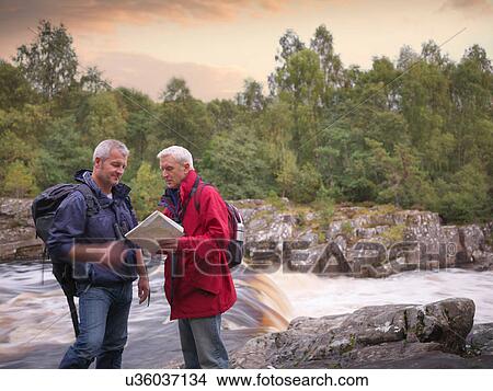 Hikers reading map by flowing Scottish river View Large Photo Image Picture - Hikers reading map by flowing Scottish river. Fotosearch