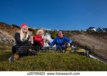 Hikers resting on patch of grass View Large Photo Image Stock Image - Hikers resting on patch of grass. Fotosearch