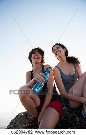 Stock Image - Hikers resting on rock. Fotosearch