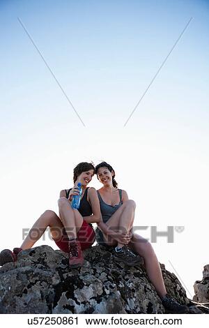 Hikers resting on rock View Large Photo Image Stock Image - Hikers resting on rock. Fotosearch