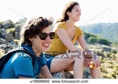 Stock Image - Hikers resting on rocks. Fotosearch