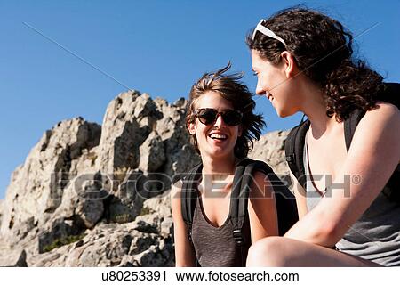 Hikers resting on rocks View Large Photo Image Stock Image - Hikers resting on rocks. Fotosearch