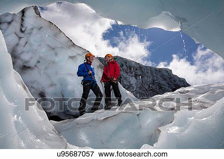 Hikers talking on melting glacier View Large Photo Image Stock Photo - Hikers talking on melting glacier. Fotosearch