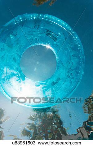 Inner tube floating in swimming pool View Large Photo Image Stock Image - Inner tube floating in swimming pool. Fotosearch