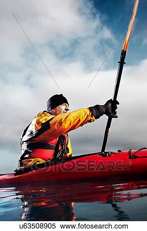Stock Photography - Kayaker paddling in water. Fotosearch
