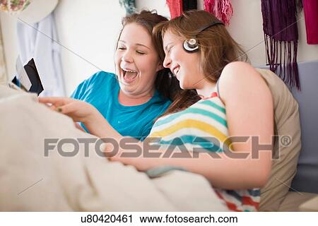 Laughing teenage girls admiring photos View Large Photo Image Stock Image - Laughing teenage girls admiring photos. Fotosearch