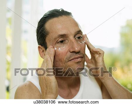 Man applying moisturizer to face View Large Photo Image Stock Photograph - Man applying moisturizer to face. Fotosearch