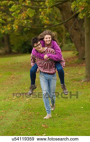 Man carrying girlfriend in park View Large Photo Image Stock Photo - Man carrying girlfriend in park. Fotosearch