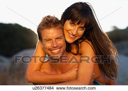 Man carrying girlfriend piggyback View Large Photo Image Picture - Man carrying girlfriend piggyback. Fotosearch