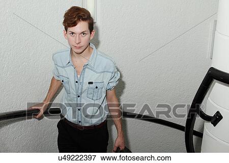 Stock Photo - Man climbing spiral staircase. Fotosearch