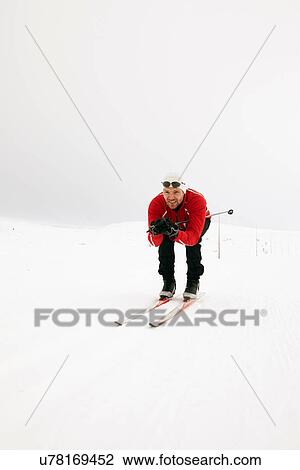 Man crouching while cross-country skiing View Large Photo Image Stock Image - Man crouching while cross-country skiing. Fotosearch