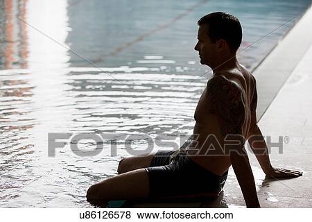 Man dangling legs in swimming pool View Large Photo Image Stock Photo - Man dangling legs in swimming pool. Fotosearch