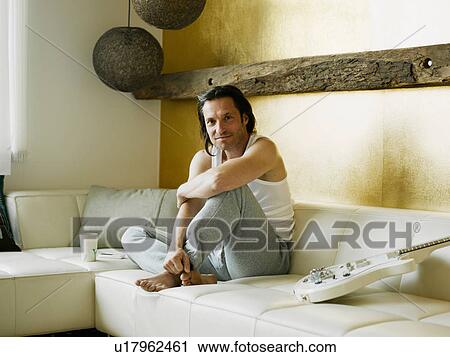 Man drinking cup of coffee on couch View Large Photo Image Stock Image - Man drinking cup of coffee on couch. Fotosearch