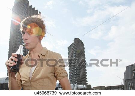 Man drinking soda on balcony View Large Photo Image Stock Photo - Man drinking soda on balcony. Fotosearch