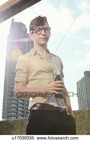 Stock Photography - Man drinking soda on balcony. Fotosearch