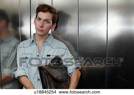 Man holding briefcase in elevator View Large Photo Image Picture - Man holding briefcase in elevator. Fotosearch