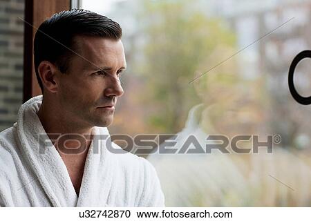 Man in bathrobe looking out window View Large Photo Image Stock Image - Man in bathrobe looking out window. Fotosearch