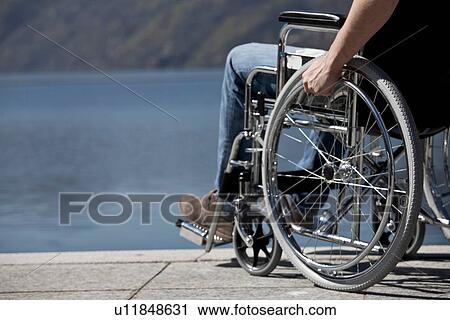 Man in wheelchair sitting by water View Large Photo Image Stock Image - Man in wheelchair sitting by water. Fotosearch
