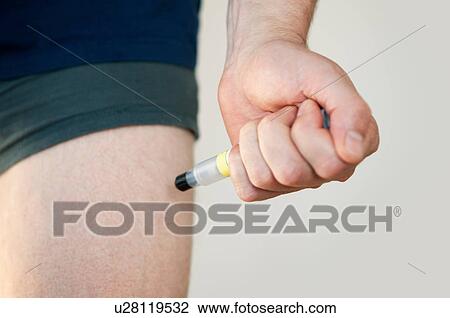 Stock Image - Man injecting himself with syringe. Fotosearch