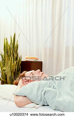Picture - Man laying in bed. Fotosearch