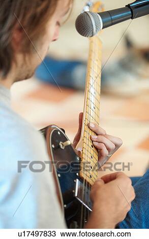 Stock Image - Man playing guitar and singing. Fotosearch